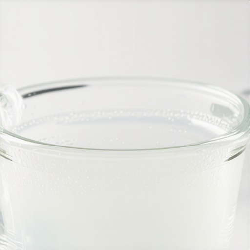 Cleaning a dental night guard with a vinegar soak A dental night guard soaking in a vinegar and water solution to remove yellow stains and cloudiness.